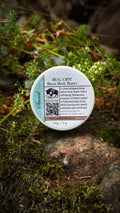 Bug Off bison body butter jar on a mossy rock