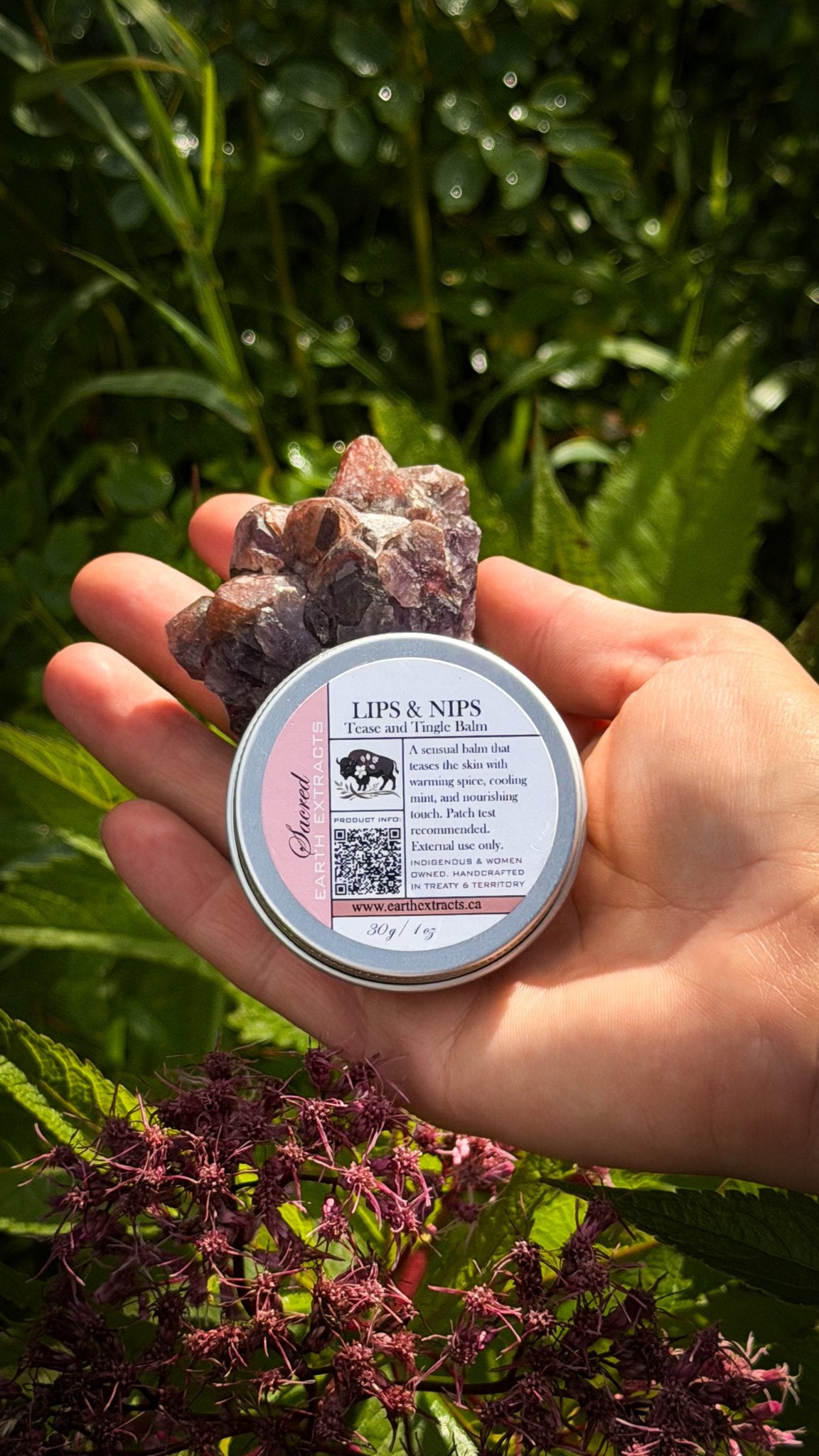 Lips and Nips tallow balm tin held in hand with a crystal