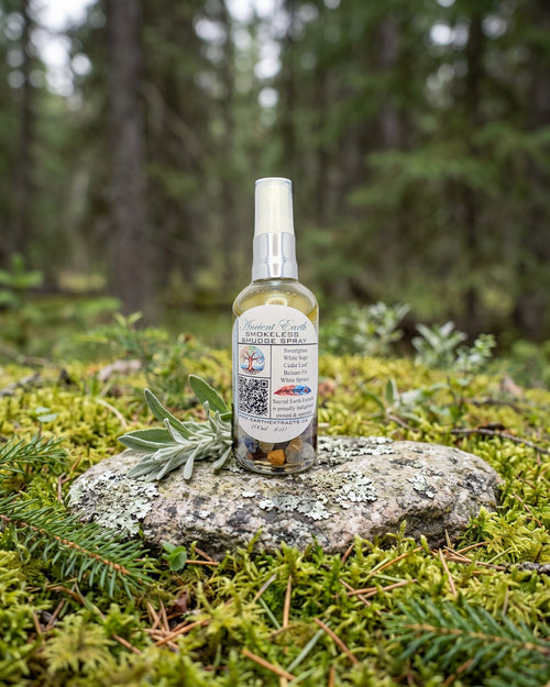 Ancient Earth Smokeless Smudge Spray on a lichen-covered granite stone on a boreal forest floor