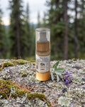 Star Lux Facial Serum on a lichen-covered granite stone on a boreal forest floor
