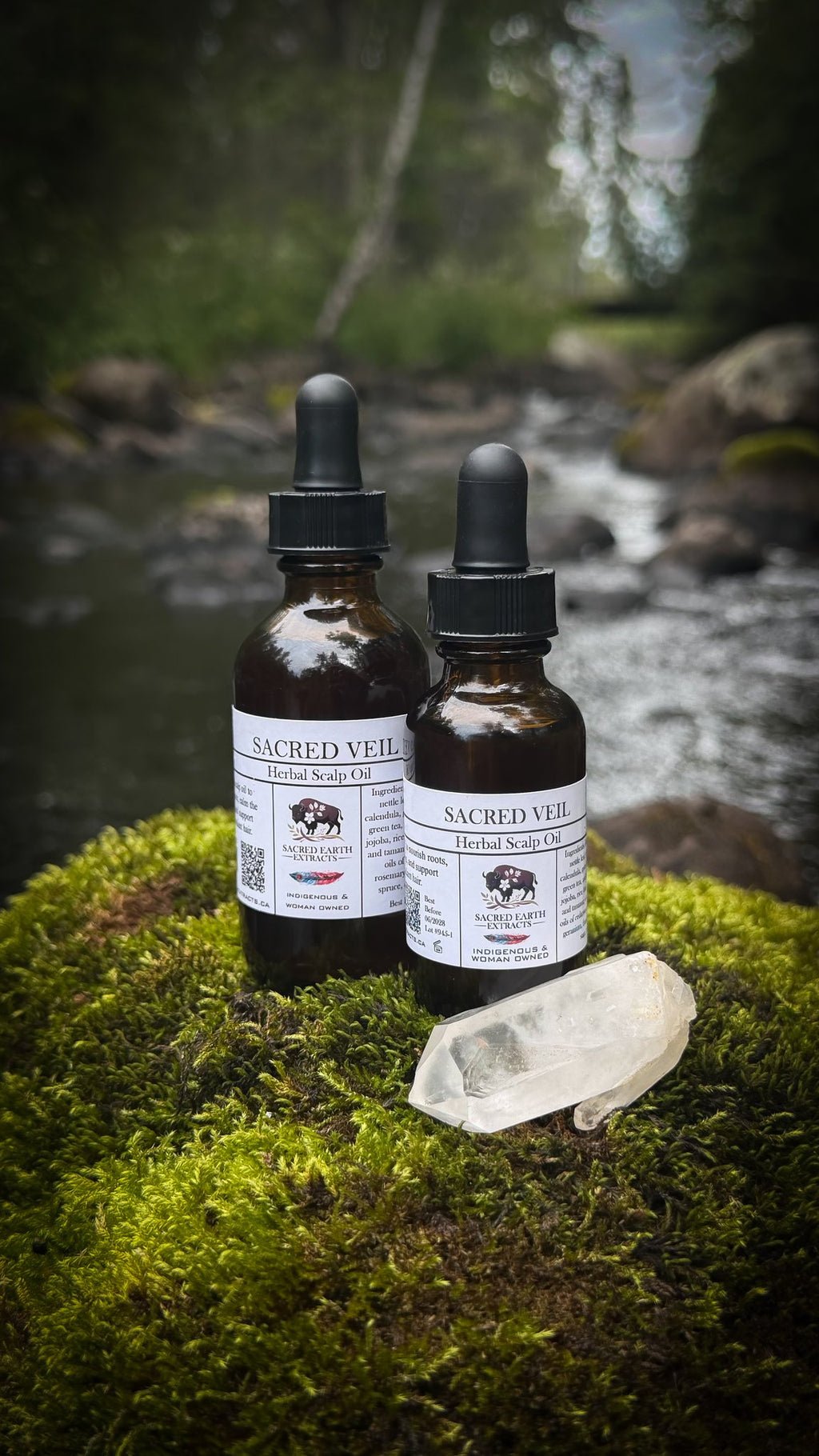 Sacred Veil herbal scalp oil bottles by the water